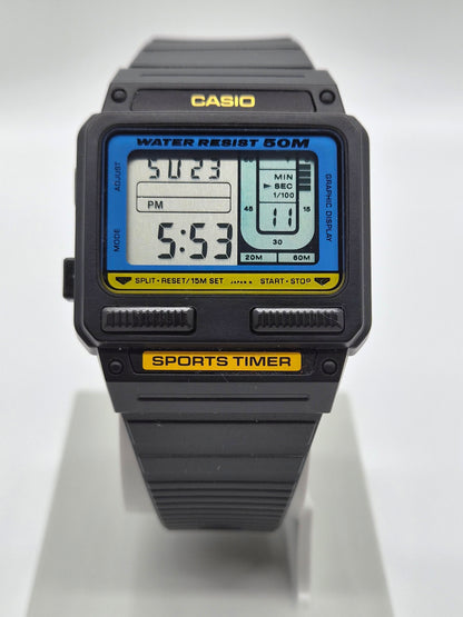 A Casio sports watch with a black plastic case and strap, featuring a blue and yellow digital display screen, shown on a white display stand.