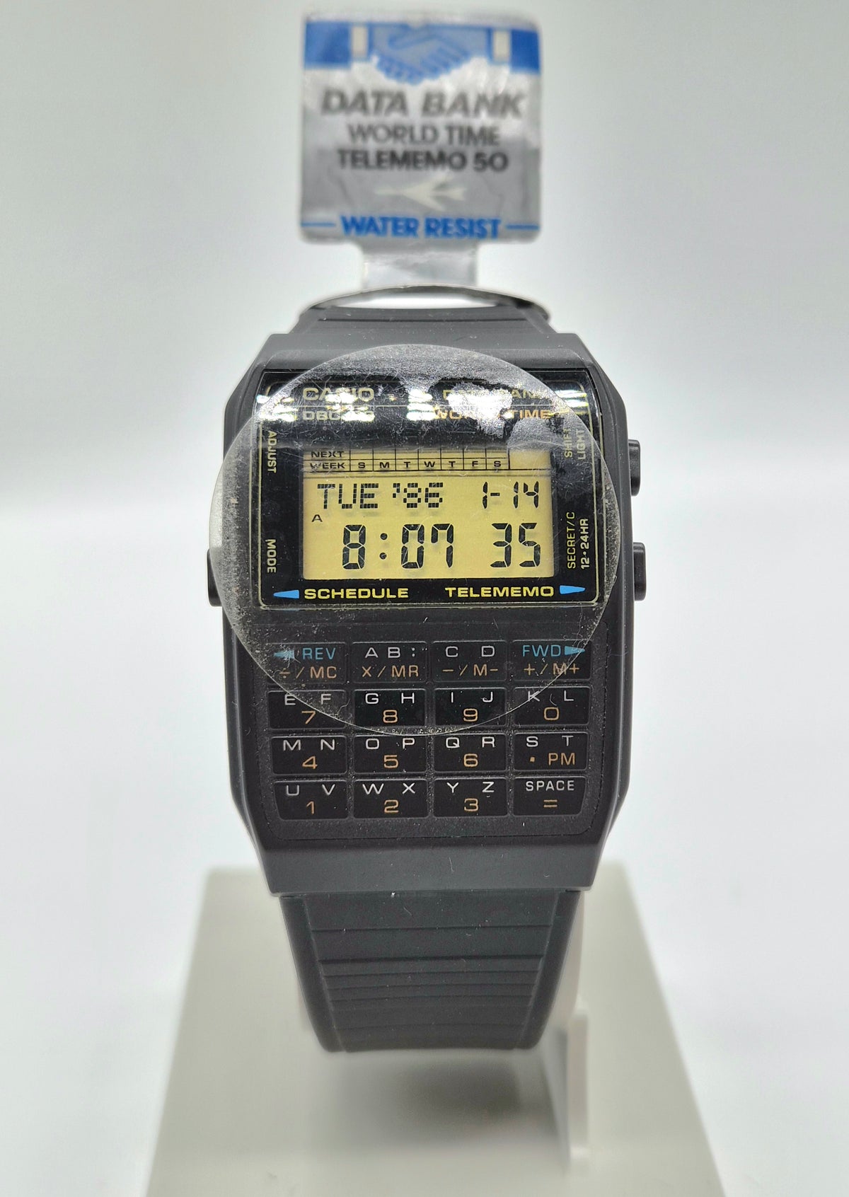 Front view of vintage Casio Data Bank World Time Telememo 50 calculator watch with black resin strap