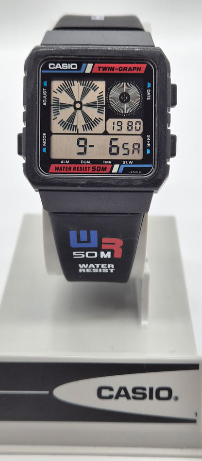 A Casio dual display watch with a black resin case and strap, featuring analog and digital screens, shown on a white display stand with a Casio-branded base.